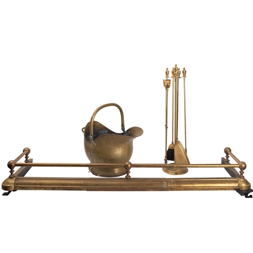 477 - An associated suite of brass fireplace furniture, comprising a fender in 19th century style, 14cm hi... 