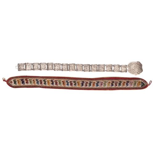 495 - An Indian beadwork belt and an Indonesian pierced white metal belt with buckle the first with a repe... 