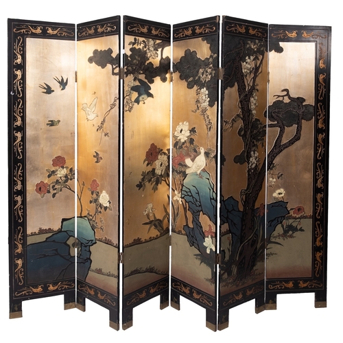 514 - An Oriental painted and lacquered wood six fold screen, early 20th century; decorated with birds on ... 