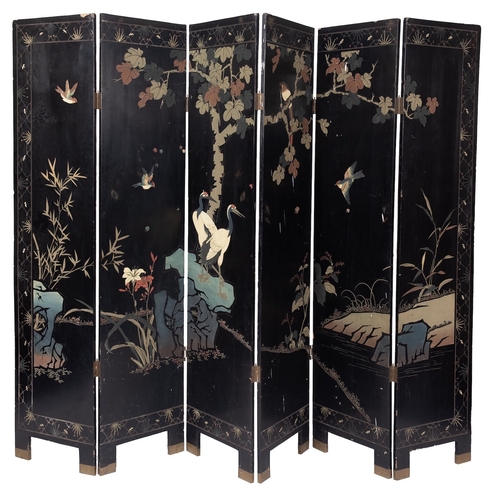 514 - An Oriental painted and lacquered wood six fold screen, early 20th century; decorated with birds on ... 