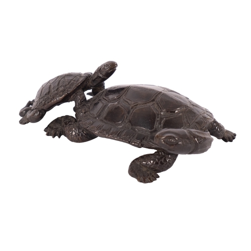 527 - A small Japanese bronze okimono of two terrapins naturalistically modelled with the smaller climbing... 