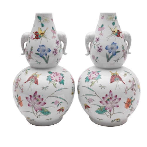 71 - A pair of Chinese porcelain double gourd vases, with elephant mask handles, enamelled in the famille... 