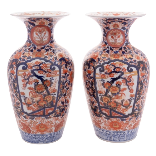 80 - A pair of Japanese Imari  vases each with waisted neck and flared rim, painted in traditional style ... 