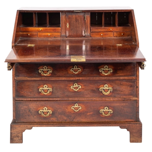 943 - A George II mahogany bureau; the sloping hinged fall enclosing a fitted interior with small drawers ... 