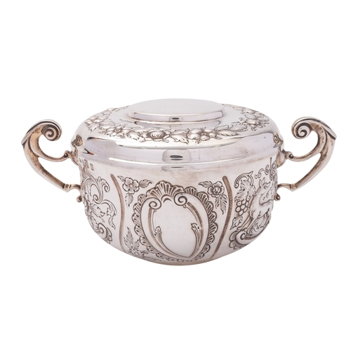 269 - An Irish silver porringer and cover, M.H Dublin 1904, in the Carolean style, decorated with birds, a... 