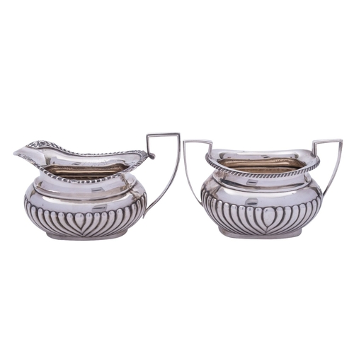 28 - A matched silver milk jug and a sugar bowl, both early 20th century of barge shape part swirl reeded... 