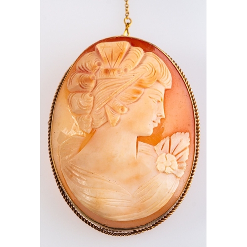 509 - A 9ct yellow gold oval cameo brooch depicting a female bust with flower, measuring approx. 6.0cm x 4... 