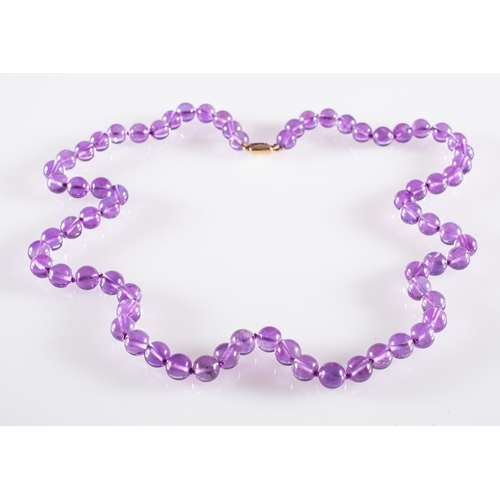 524 - An Amethyst bead necklace, circular 8mm amethyst beads to a 9ct yellow gold clasp, clasp marked 9ct,... 