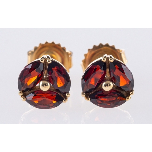 565 - A pair of 9ct yellow gold & garnet stud earrings, each set with three marquise-cut garnets, UK impor... 