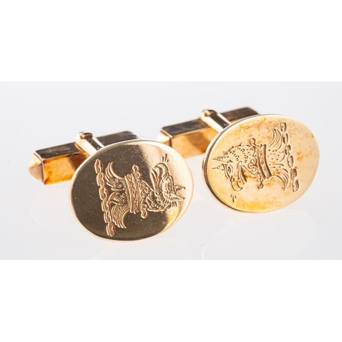 578 - A pair of cufflinks, of oval design with crest engraving, fixed bar link and articulated toggle fitt... 