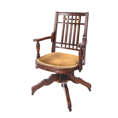 173 - A Victorian oak revolving desk elbow chair, circa 1900, with reeded and turned back and bowed uphols... 