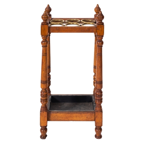 178 - An oak and brass stick stand, circa 1900, with six circular divisions, urn finials and oblong metal ... 