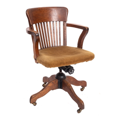 230 - A Edwardian oak  revolving office desk arm chair, circa 1910, the back with curved bar top rail and ... 