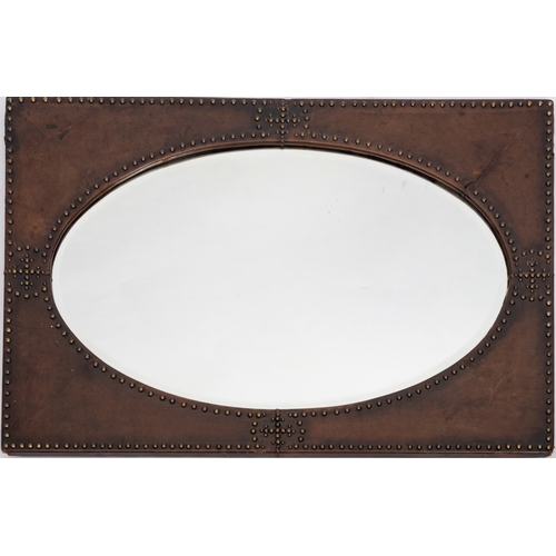 239 - A studded leather veneered wall mirror, in Arts & Crafts taste, early 20th century; with bevelled ov... 