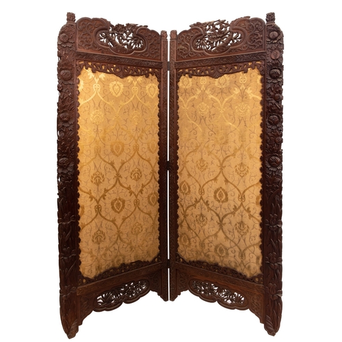 256 - A Victorian Anglo Indian carved wood two-fold screen with beige fabric panels, having pierced and bl... 