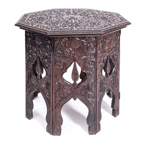 257 - An Anglo Indian carved hardwood octagonal occasional table on integral stand, the top with all over ... 