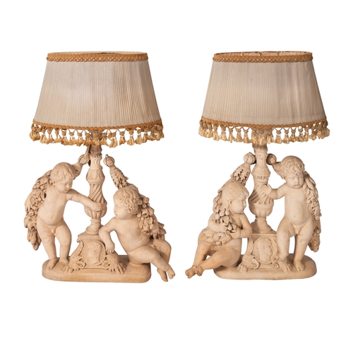 351 - A pair of plaster groups of cavorting putti fitted as table lamps, 20th Century, the central Italian... 