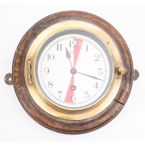 155A - A brass and oak Radio Room bulkhead clock, the white enamel dial with Arabic numerals and red sector... 