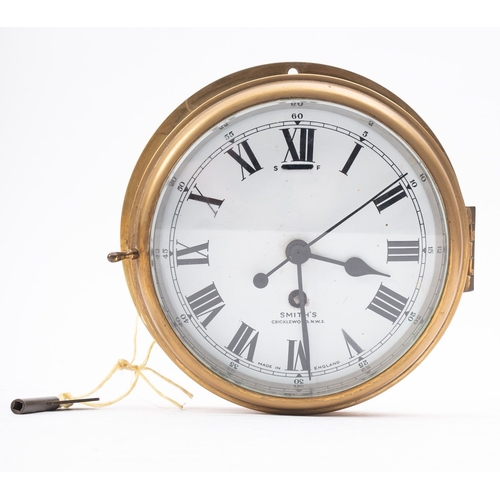 165A - A Smiths brass bulkhead clock, with white enamel dial and Roman numerals signed as per title, 23.5cm... 