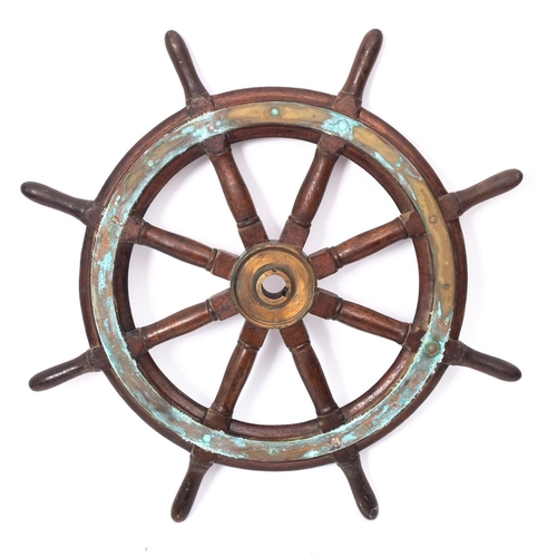 178 - A teak and brass ship's helm, the central brass boss radiating block and turned spars, 67cm