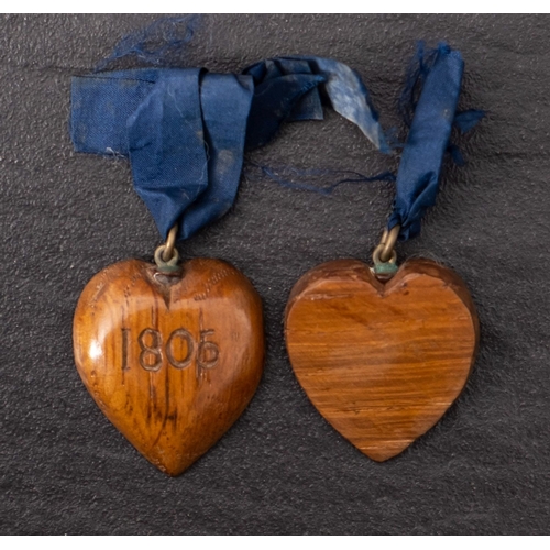 334A - Two 19th century oak heart shaped pendants both inscribed 'Victory 1805' with blue ribbon suspension... 