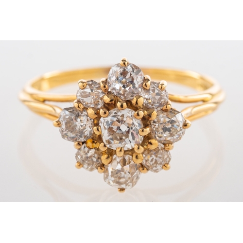 828 - Garrard. An 18ct yellow gold diamond cluster ring, claw set with nine old-cut diamonds, diamonds app... 