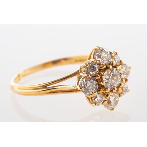 828 - Garrard. An 18ct yellow gold diamond cluster ring, claw set with nine old-cut diamonds, diamonds app... 