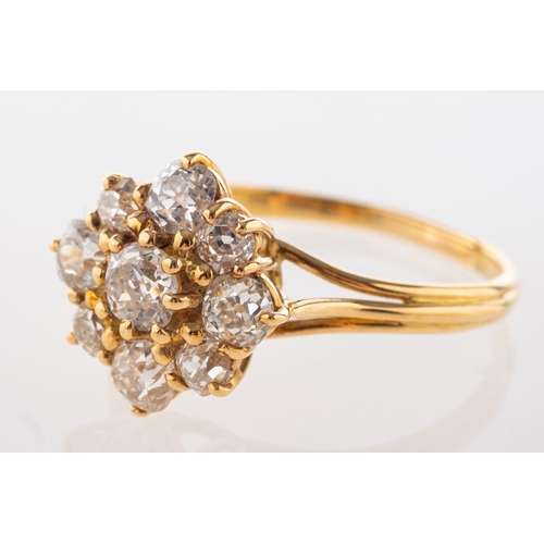 828 - Garrard. An 18ct yellow gold diamond cluster ring, claw set with nine old-cut diamonds, diamonds app... 