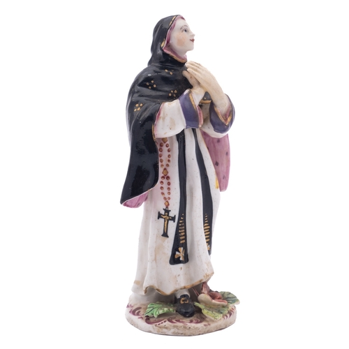 106 - A Bow figure of a nun modelled standing with hands crossed and wearing habit and veil, the base appl... 