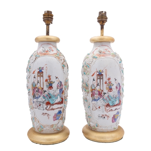 13 - A pair of Chinese famille rose moulded vases painted with cartouches of family groups in interiors o... 