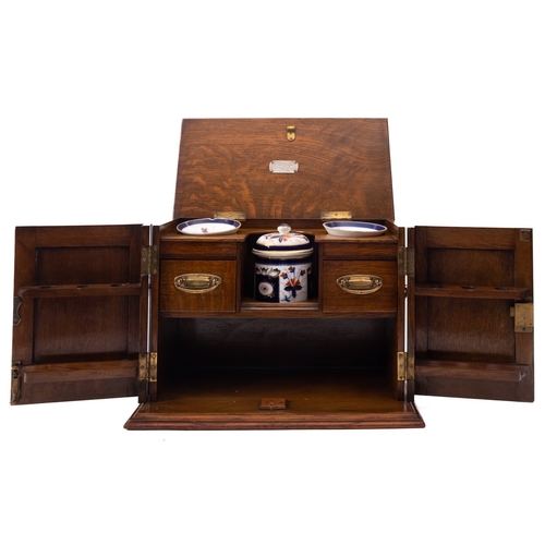 206 - An Edwardian oak and brass mounted smoker's cabinet, early 20th century; the hinged top with moulded... 