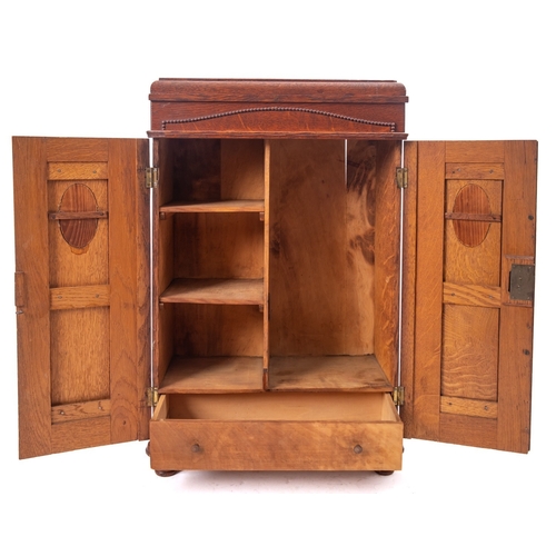 235 - A miniature oak wardrobe in Art Deco style, circa 1930; possibly an apprenticeman's piece, with moul... 