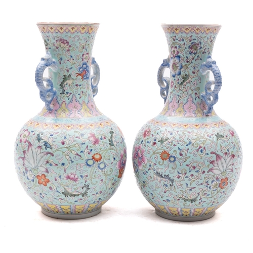 26 - A pair of Chinese famille rose baluster vases with dragon handles, painted with lotus, peony, other ... 