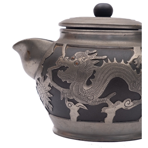 31 - A Chinese Yixing pewter mounted three piece tea service, the black body mounted with sinuous dragons... 