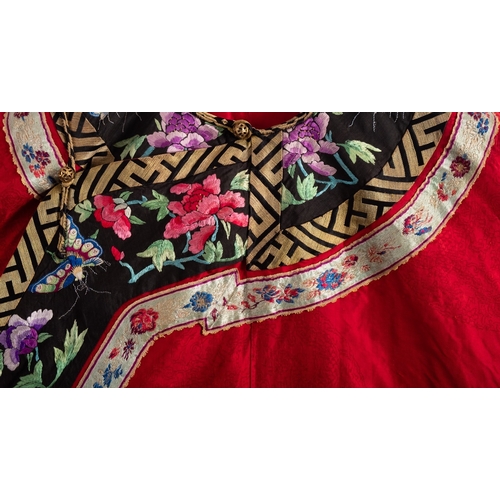 346 - A Chinese lady's red-ground silk damask robe trimmed with black silk borders embroidered with bright... 