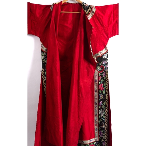 346 - A Chinese lady's red-ground silk damask robe trimmed with black silk borders embroidered with bright... 