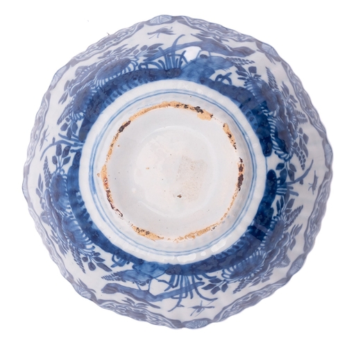 52 - A Dutch blue and white delftware bowl of ribbed rounded octagonal form, painted with birds and insec... 