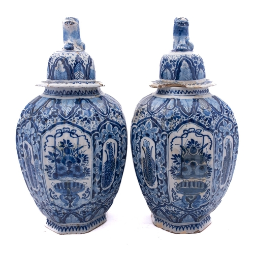 53 - A pair of Dutch blue and white delftware baluster vases and covers of ribbed octagonal form, the cov... 