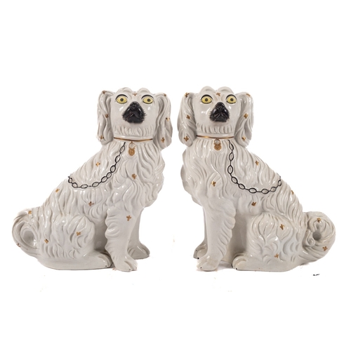 55 - A pair of Staffordshire comforter spaniels, each modelled with independent leg with painted details,... 