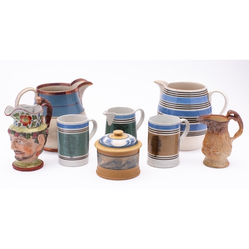 60 - A group of mocha ware, comprising two jugs, two tankards and a tobacco jar and cover, together with ... 