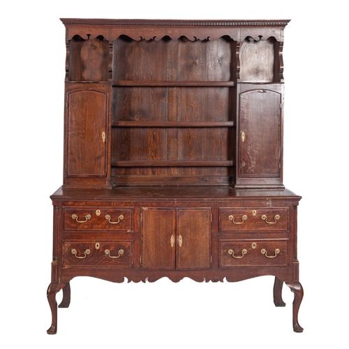 751 - A George III oak and crossbanded dresser, circa 1800; the plate rack with dentilled cornice above fr... 