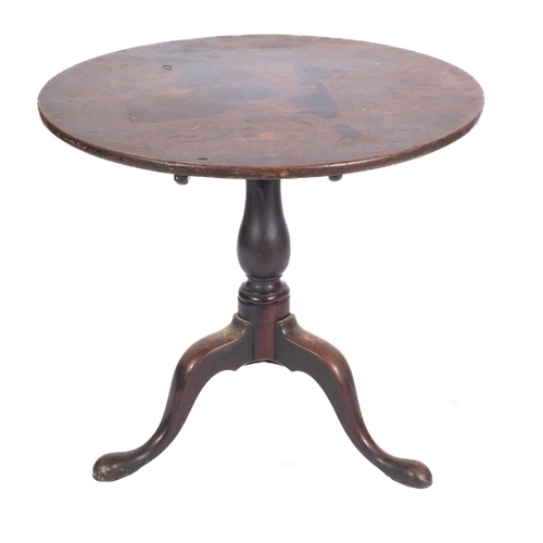 763 - An 18th Century oak circular tea table, with a snap top on turned baluster column and tripod support... 