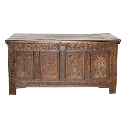 769 - An early 18th Century and later carved oak rectangular coffer, with a plain hinged top, the front wi... 