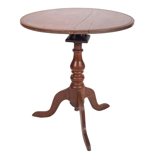 775 - A 19th Century oak circular occasional table, the snap top with a moulded edge on turned baluster co... 