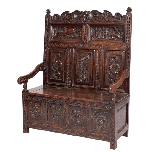 777 - A carved oak bacon settle in, late 17th century taste, late 19th century; the backrest toprail with ... 