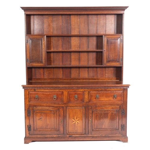 787 - A 19th Century oak dresser, the shelved superstructure with a moulded dentil cornice and twin enclos... 