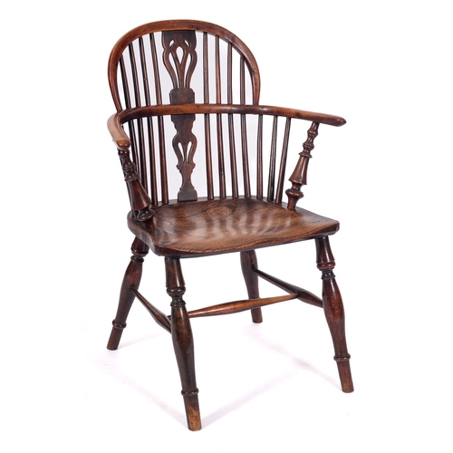 788 - An early 19th Century yew-wood and elm stick back Windsor elbow chair, the back with a pierced and s... 