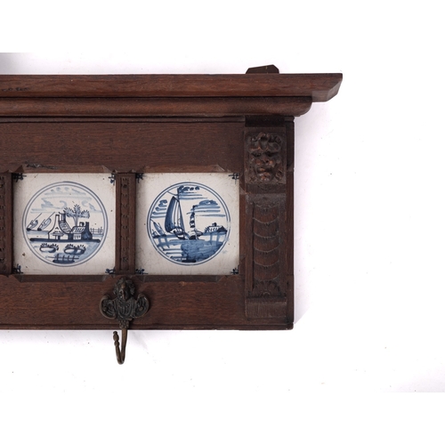 789 - A carved oak Delft tile mounted coat hook panel, 19th century construction, the tiles earlier; with ... 