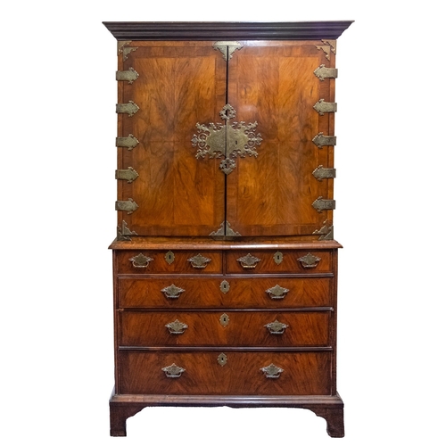 790 - A Queen Anne walnut cabinet on chest, circa 1710, the moulded cornice above two quarter veneered doo... 