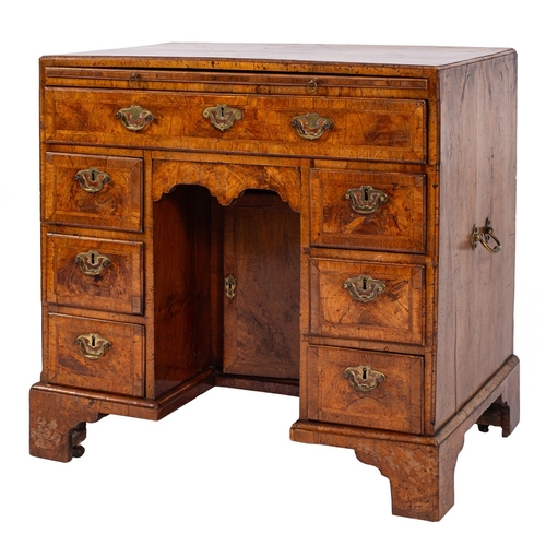 806 - A George II walnut and feather and crossbanded kneehole desk, circa 1740; with quarter veneered top ... 